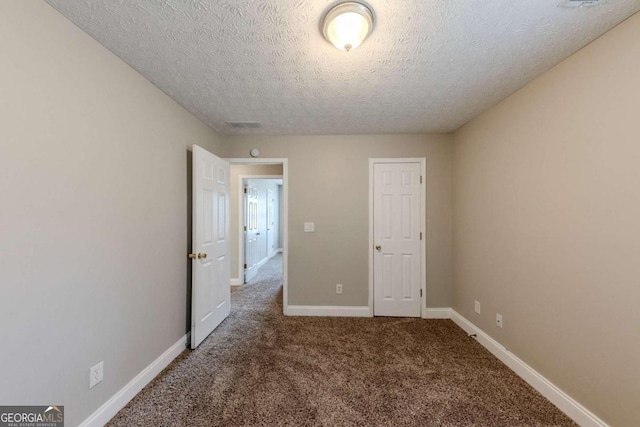 unfurnished bedroom featuring carpet floors and a textured ceiling