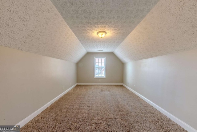 bonus room with lofted ceiling, a textured ceiling, and carpet flooring