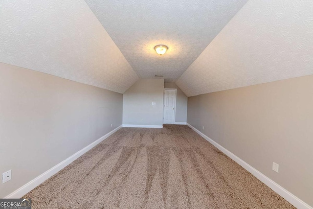 bonus room featuring lofted ceiling, a textured ceiling, and carpet flooring