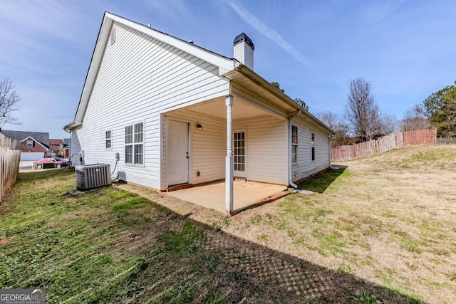 rear view of house featuring a patio area, central AC unit, and a lawn