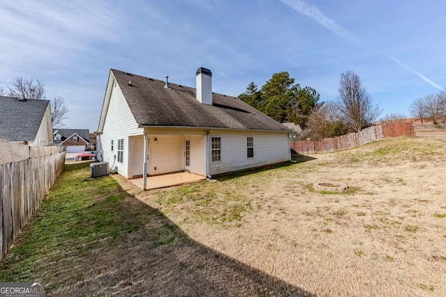 rear view of property with a patio area, a lawn, and central AC