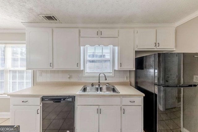 kitchen with black dishwasher, sink, white cabinetry, and stainless steel refrigerator