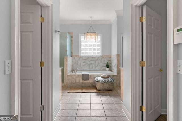 bathroom with tiled bath, tile patterned flooring, crown molding, and a chandelier