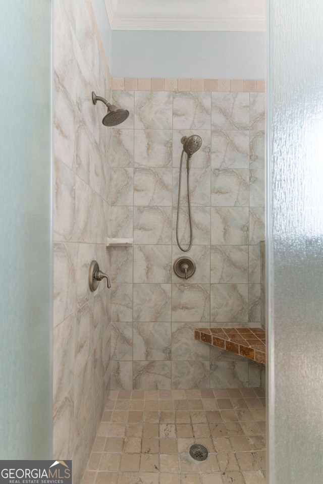 bathroom with ornamental molding and a tile shower