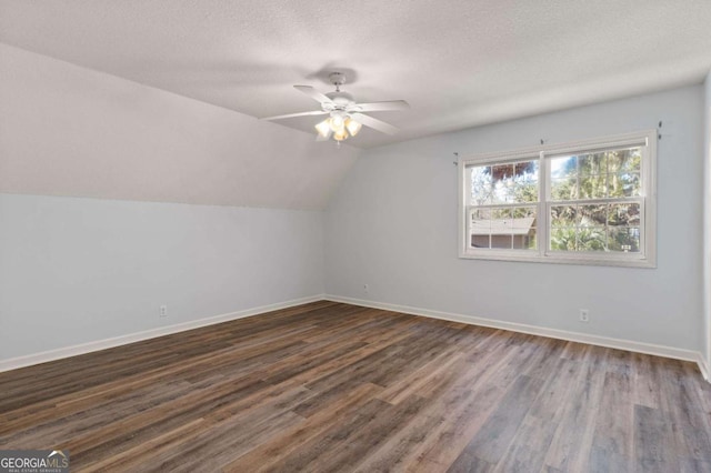 bonus room with ceiling fan, dark wood-type flooring, a textured ceiling, and vaulted ceiling