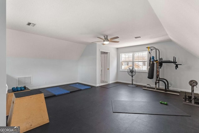 workout area with ceiling fan, vaulted ceiling, and a textured ceiling