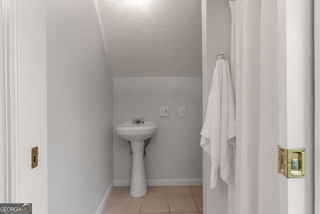 bathroom featuring vaulted ceiling and tile patterned floors