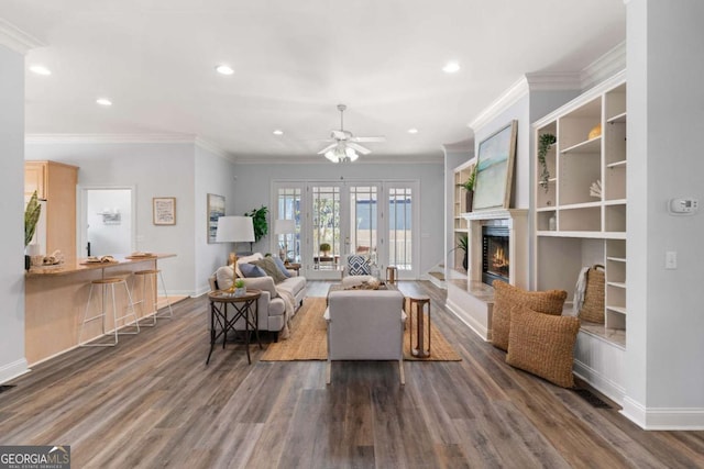 living room featuring ceiling fan, french doors, dark hardwood / wood-style floors, and crown molding