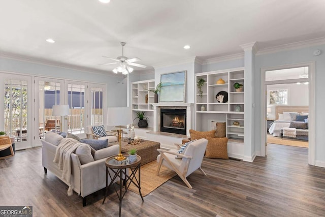 living room with dark hardwood / wood-style floors, ceiling fan, crown molding, and plenty of natural light