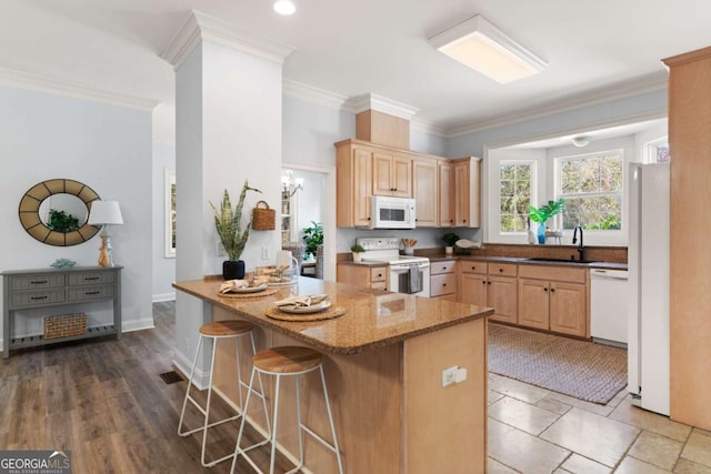 kitchen featuring a kitchen breakfast bar, white appliances, sink, and kitchen peninsula