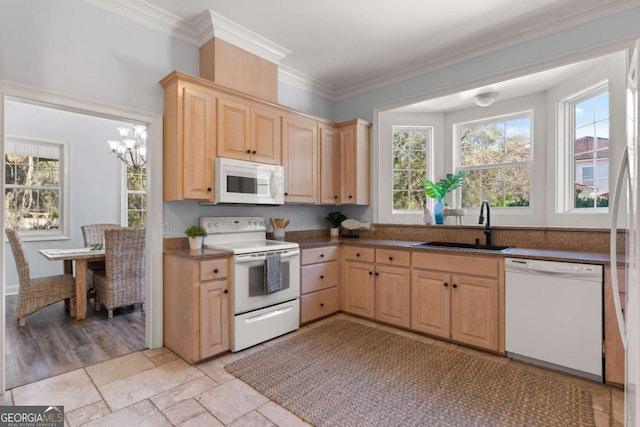 kitchen featuring sink, white appliances, a wealth of natural light, and a notable chandelier