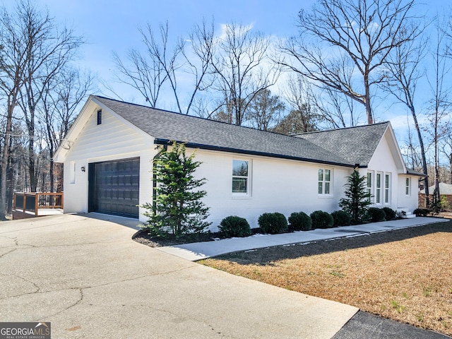 view of side of home with a garage and a lawn