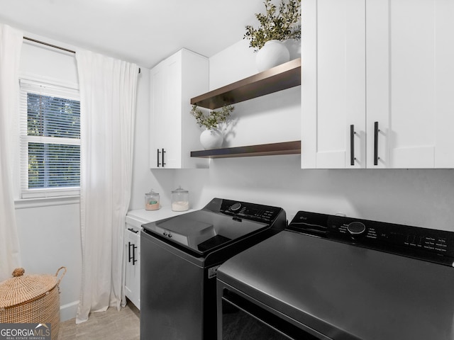 laundry room featuring cabinets and washing machine and clothes dryer