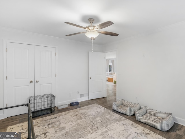 bedroom with ceiling fan, a closet, dark wood-type flooring, and crown molding