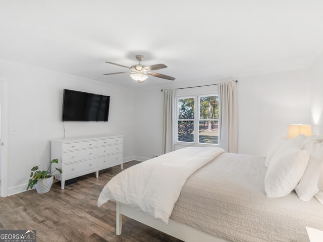 bedroom featuring ceiling fan, dark hardwood / wood-style floors, and crown molding