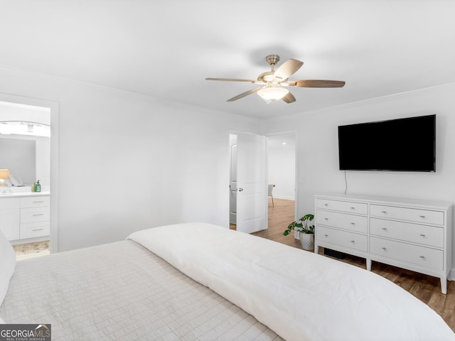 bedroom featuring dark wood-type flooring, ceiling fan, ensuite bathroom, and crown molding