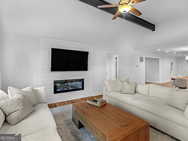 living room featuring ceiling fan, hardwood / wood-style floors, lofted ceiling with beams, and a fireplace