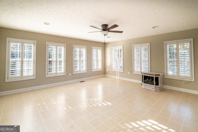 spare room featuring carpet floors, ceiling fan, and a textured ceiling