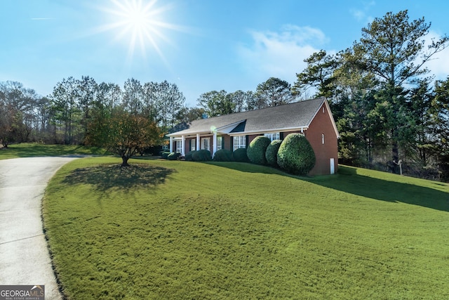 ranch-style home with concrete driveway and a front lawn