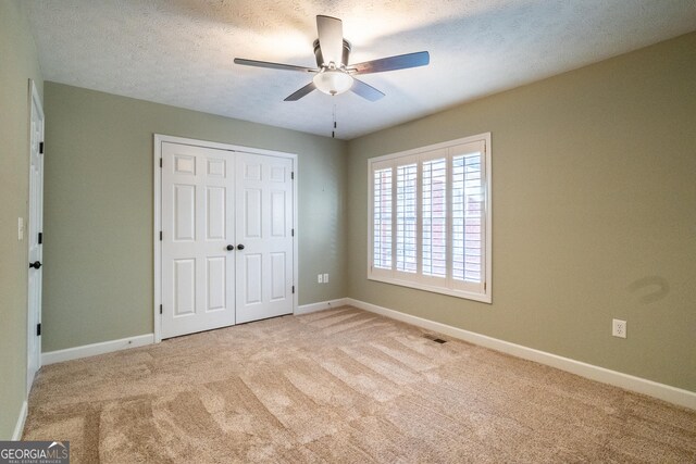 tiled spare room featuring a textured ceiling and ceiling fan