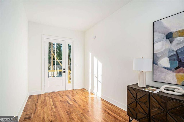 entryway with light wood-style flooring, visible vents, and baseboards