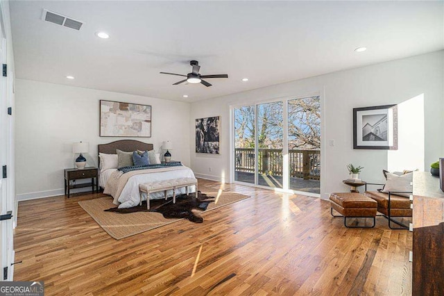 bedroom with access to outside, wood finished floors, visible vents, and recessed lighting