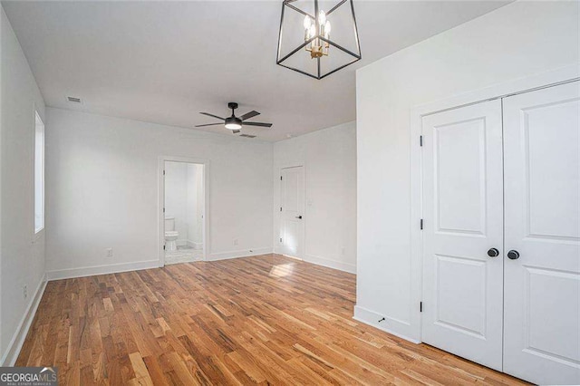 interior space with connected bathroom, visible vents, baseboards, a closet, and light wood finished floors