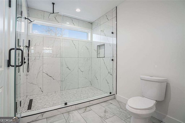 bathroom with marble finish floor, baseboards, a shower stall, and toilet