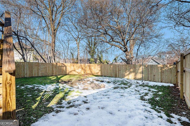 yard layered in snow featuring a fenced backyard