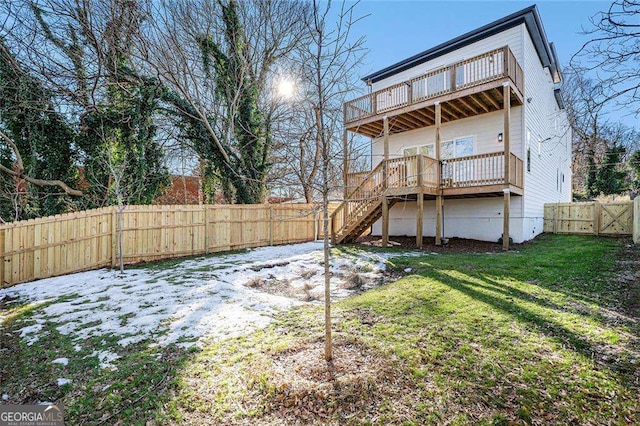 rear view of house with a fenced backyard, a lawn, a deck, and stairs