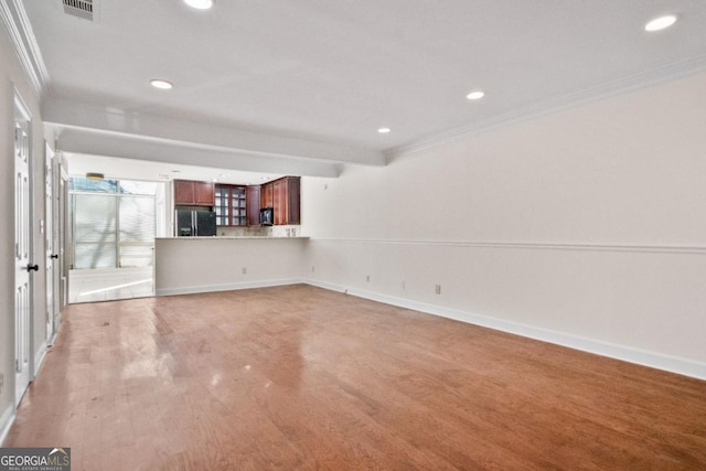 unfurnished living room with wood-type flooring and ornamental molding