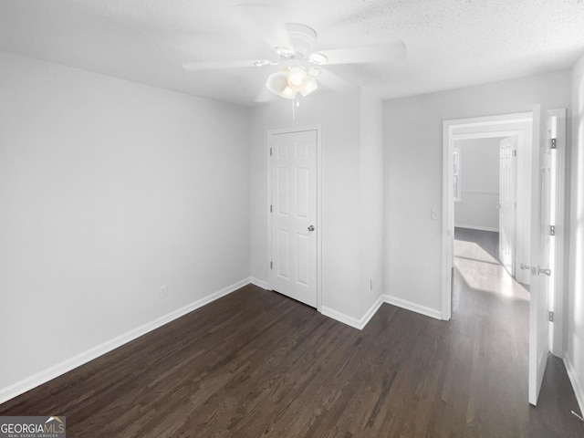 spare room featuring ceiling fan, dark hardwood / wood-style flooring, and a textured ceiling