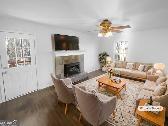 living room featuring ceiling fan, a tile fireplace, and dark hardwood / wood-style flooring