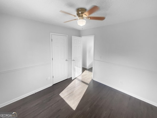 empty room with ceiling fan and dark hardwood / wood-style flooring