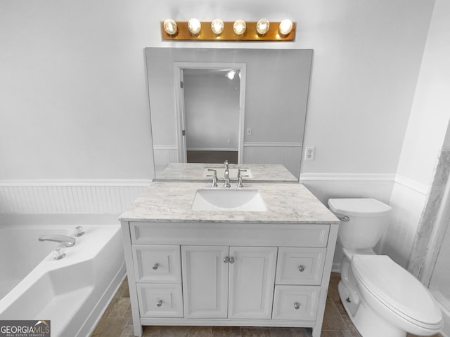 bathroom featuring toilet, a tub to relax in, tile patterned floors, and vanity