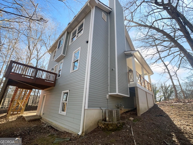 view of property exterior with central air condition unit and a wooden deck