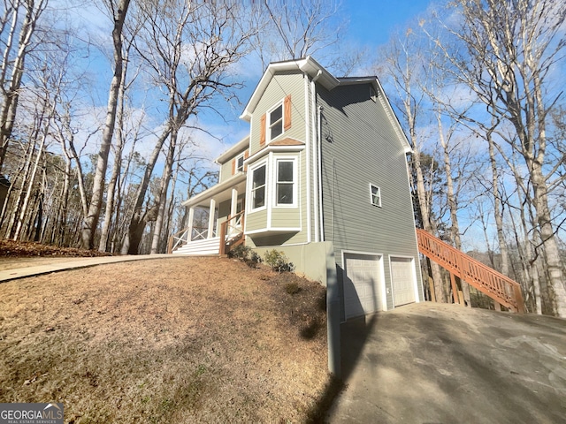 view of property exterior featuring a garage and a porch