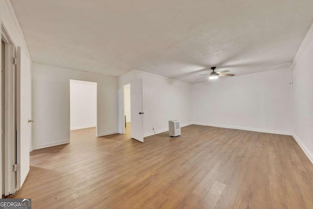 interior space featuring ceiling fan, light wood-type flooring, and crown molding