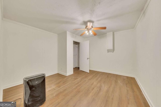 unfurnished bedroom with ceiling fan, light hardwood / wood-style floors, a textured ceiling, and crown molding