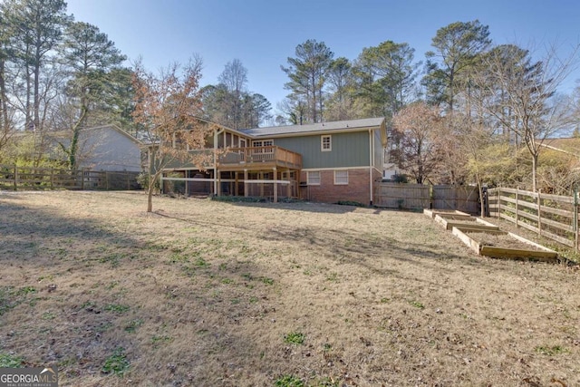 rear view of property featuring a wooden deck and a yard