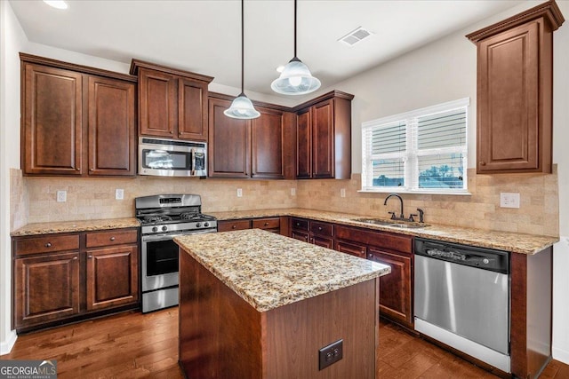 kitchen featuring stainless steel fridge, beam ceiling, light stone counters, a kitchen island, and ceiling fan with notable chandelier