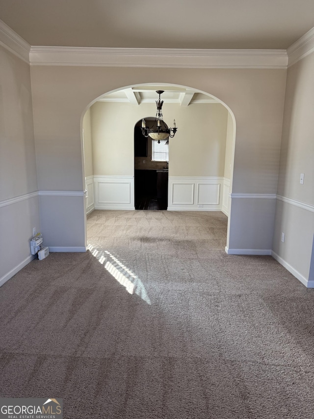 unfurnished living room with light carpet, an inviting chandelier, ornamental molding, and beamed ceiling