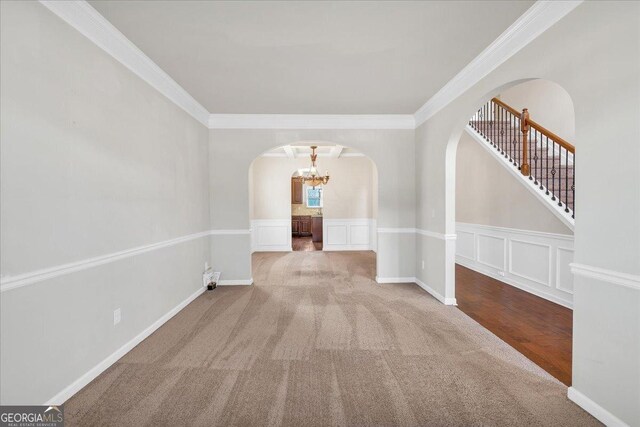 interior space featuring an inviting chandelier, carpet floors, and ornamental molding