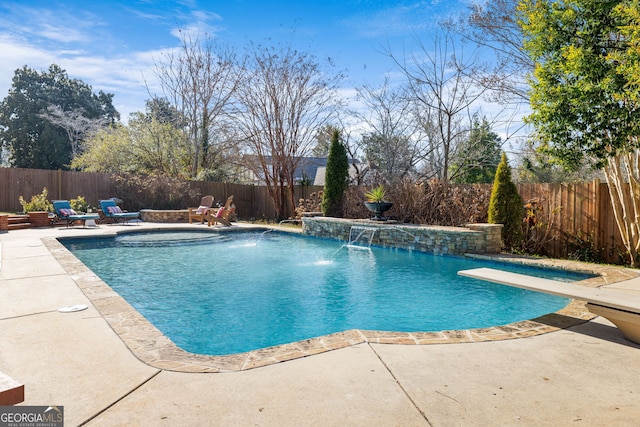 view of pool featuring pool water feature, a hot tub, and a diving board