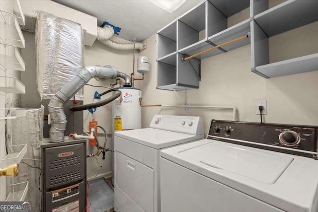 laundry area with water heater, washing machine and dryer, and a textured ceiling