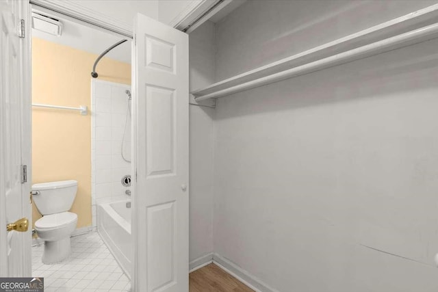 bathroom featuring washtub / shower combination and toilet