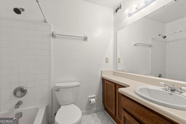 full bathroom featuring vanity, tile patterned flooring, tiled shower / bath combo, and toilet