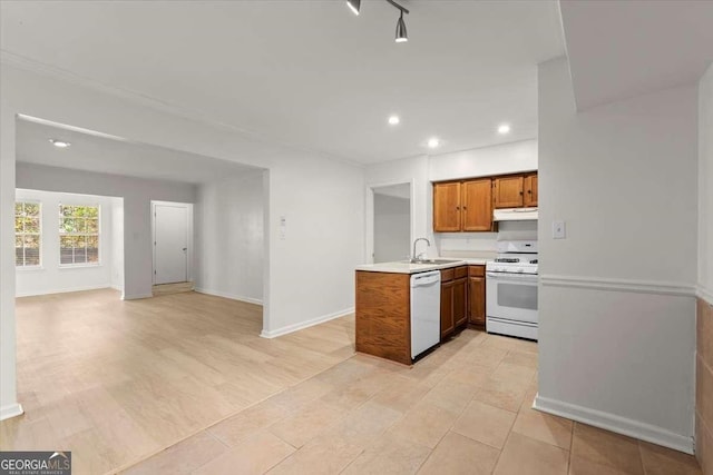 kitchen featuring sink, light tile patterned floors, white appliances, and kitchen peninsula