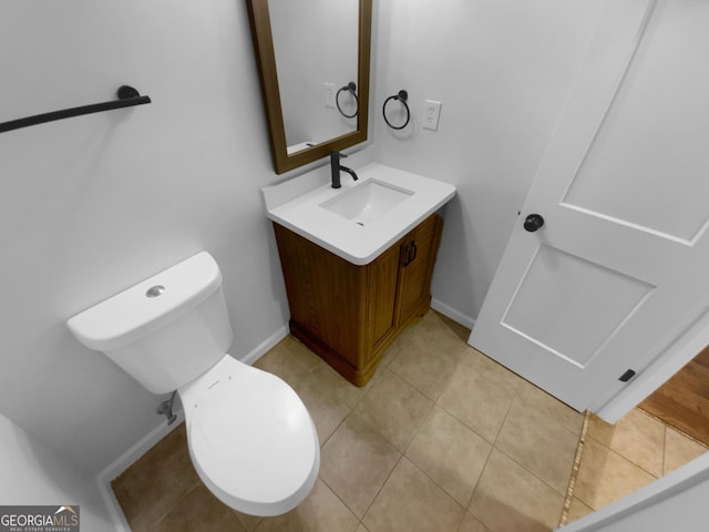 bathroom with toilet, tile patterned floors, and vanity