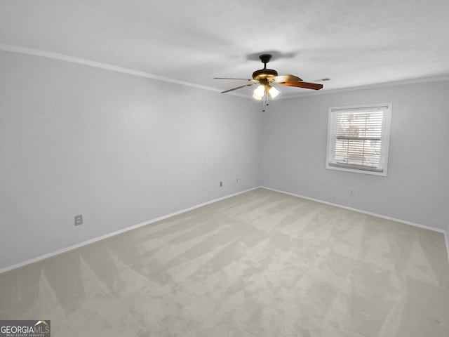 unfurnished room with ceiling fan, light colored carpet, and crown molding